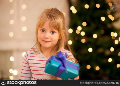 Girl in front of a Christmas tree with presents