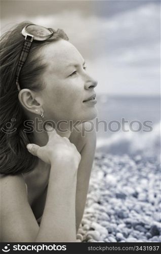 girl in glasses on the shore and looks at sea