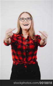 Girl in glasses, plaid shirt. Young woman showing middle finger on a white background.. Girl in glasses, plaid shirt. Young woman showing middle finger on a white background