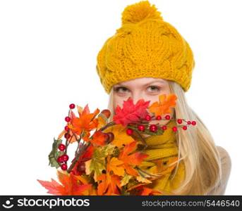 Girl in hat and scarf hiding behind autumn bouquet