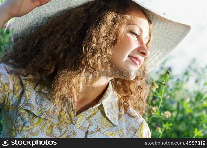 Girl in hat. Young beautiful girl in hat and glasses sitting in grass