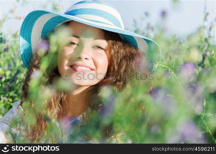 Girl in hat. Young beautiful girl in hat and glasses sitting in grass
