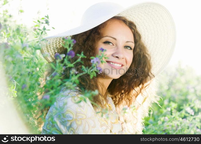 Girl in hat. Young beautiful girl in hat and glasses sitting in grass