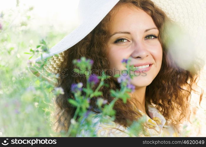 Girl in hat. Young beautiful girl in hat and glasses sitting in grass