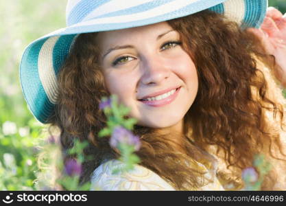 Girl in hat. Young beautiful girl in hat and glasses sitting in grass