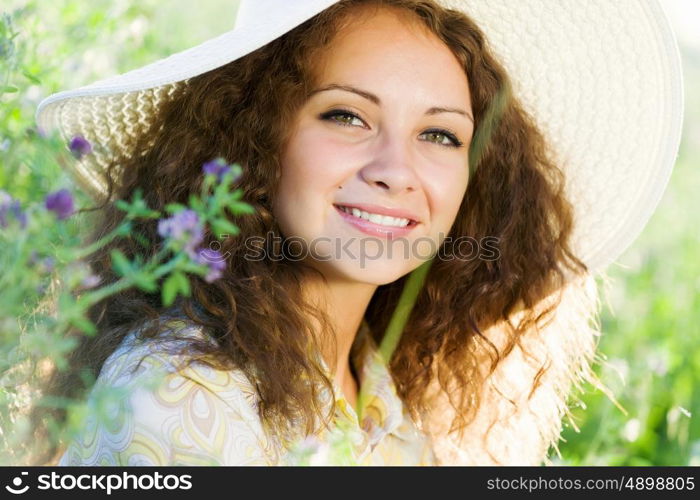 Girl in hat. Young beautiful girl in hat and glasses sitting in grass