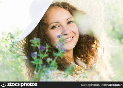 Girl in hat. Young beautiful girl in hat and glasses sitting in grass