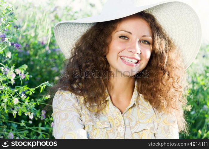 Girl in hat. Young beautiful girl in hat and glasses sitting in grass