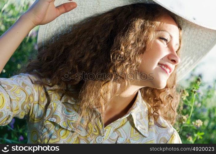 Girl in hat. Young beautiful girl in hat and glasses sitting in grass