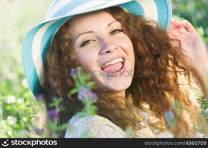 Girl in hat. Young beautiful girl in hat and glasses sitting in grass