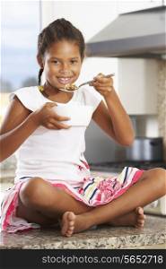 Girl In Kitchen Eating Bowl Of Breakfast Cereal