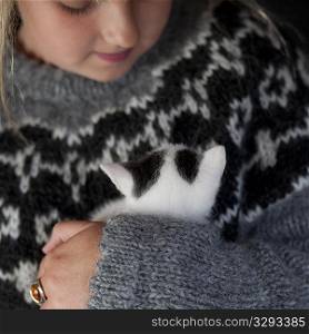 Girl in knit sweater with kitten