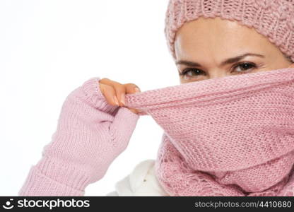 Girl in knit winter clothing closing face with scarf