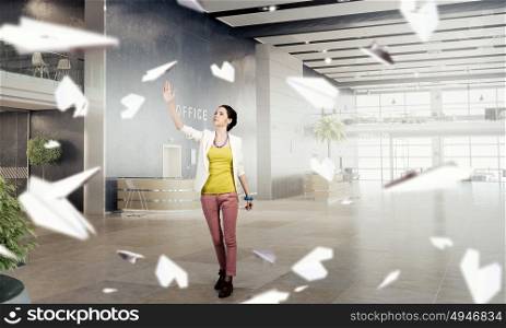 Girl in office interior mixed media. Young woman in modern office interior reaching hand to touch item