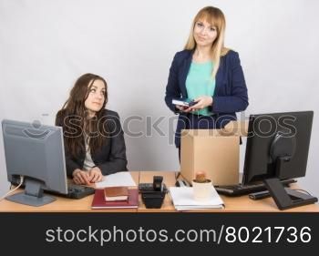 Girl in office standing with a smile in front of a box about colleagues