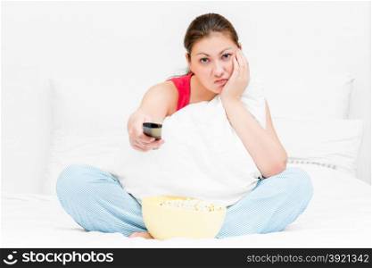 girl in pajamas with remote control TV dissatisfied