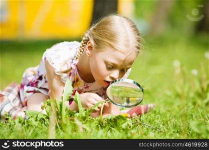 Girl in park. Image of cute boy playing in park with magnifier