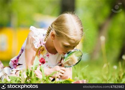 Girl in park. Image of cute boy playing in park with magnifier