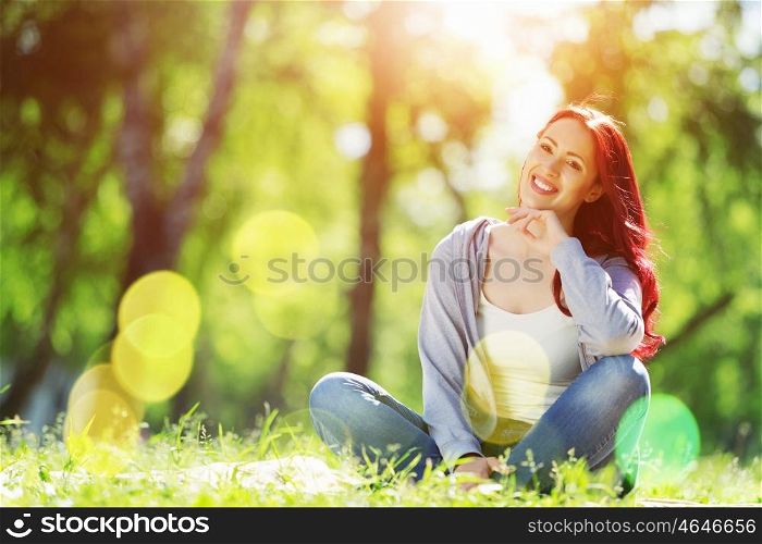 Girl in park. Pretty girl in summer park sitting on grass
