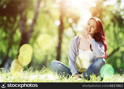 Girl in park. Pretty girl in summer park sitting on grass