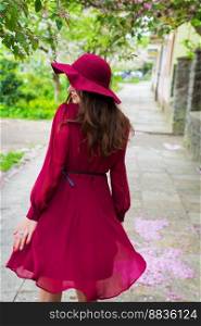 girl in red dress and hat - rear view. girl in red dress and hat