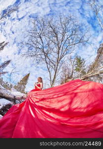 girl in red dress. Forest in winter