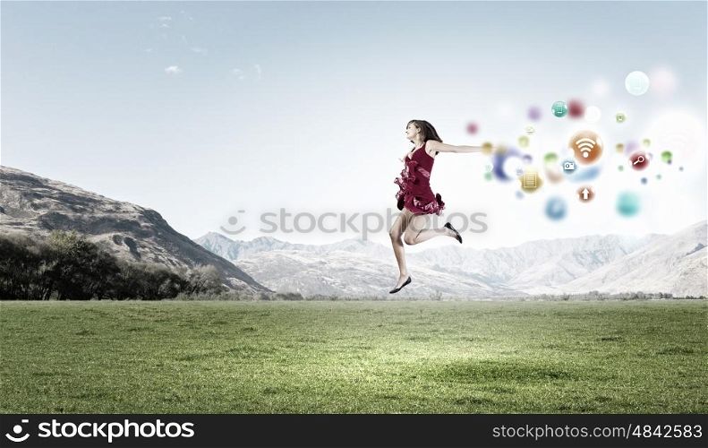 Girl in red dress. Young cheerful lady in red dress jumping high