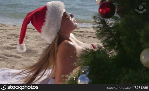 Girl in Santa hat enjoying Christmas holidays on the beach resort