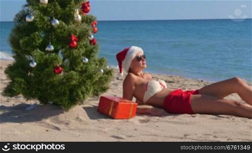 Girl in Santa hat enjoying Christmas vacation time on beach resort