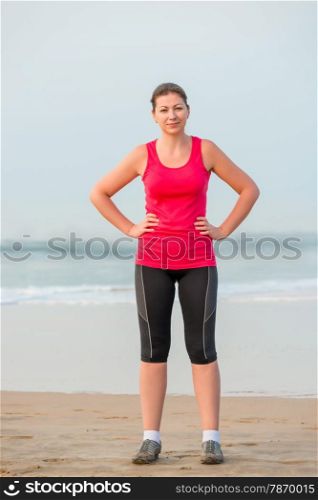 Girl in sportswear before exercise on the beach