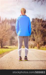 Girl in sportswear is waiting to start her training, countryside