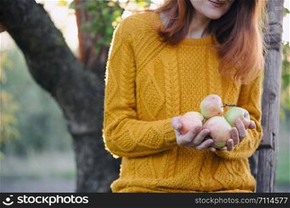girl in the garden holding apples at sunset