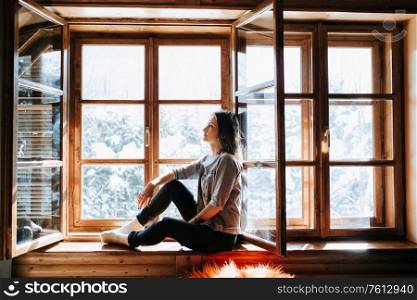 girl in the house near the window overlooking a snowy landscape