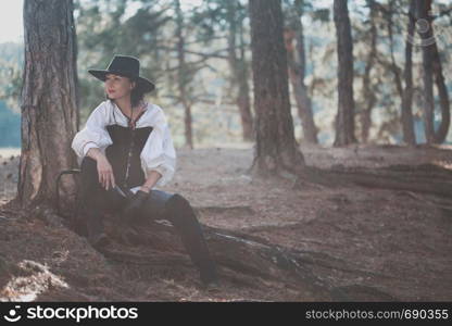 girl in the image of a cowboy in the forest in the sunset light