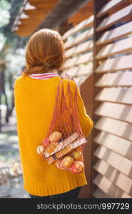 girl in the park with a string bag with books and apples. autumn mood