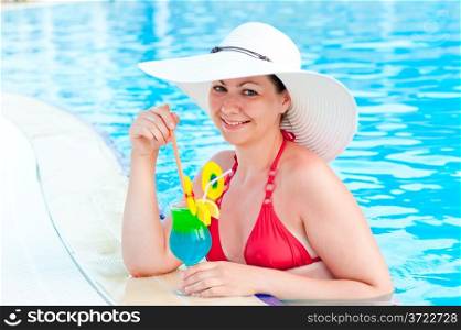girl in the pool with a cocktail smiles