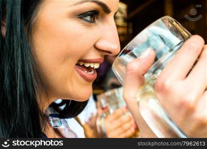 Girl in traditional Dirndl dress, Russian touch but could also be Greek, is drinking beer and having fun at the Oktoberfest