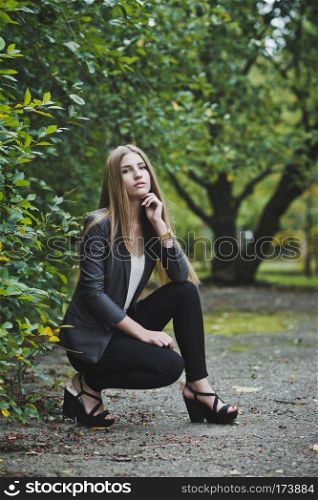 Girl in trousers and a suit on a walk.. Girl sitting near the Bush 3689.