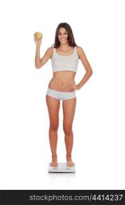 Girl in underwear with an apple weighing yourself on a scale isolated