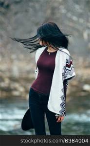 girl in warm sweater walking along a mountain river, love story