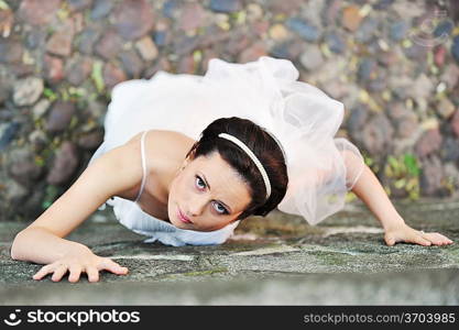 girl in wedding dress near old wall