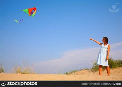 Girl in white dress runs kite