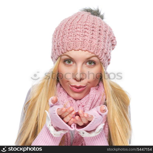 Girl in winter clothes blowing snow from hands