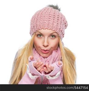 Girl in winter clothes blowing snow from hands