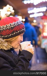 Girl is drinking mulled wine on the Christmas market, fun