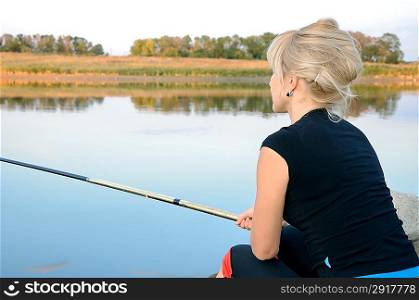 Girl is fishing on a lake