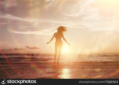 girl is having fun and jumping on beach freedom / concept freedom and summer  beach, sporty graceful girl is jumping and having fun  beach