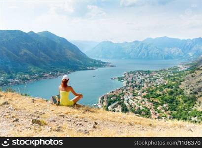 Girl is sitting on the mountain infront of the sea
