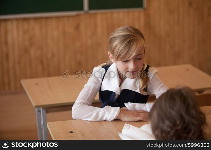 Girl is studying in classrom at the desk. Girl is studying