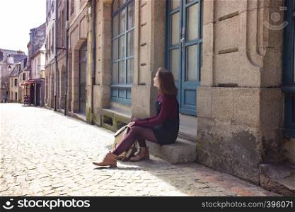 girl is walking along an empty street in the old town Morlaix. France
